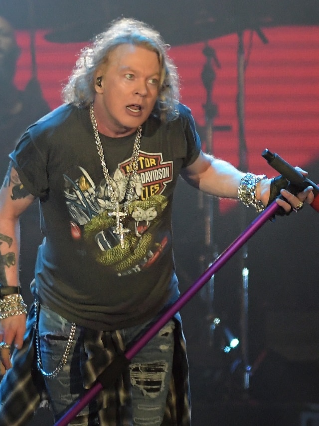Axl Rose em show do Guns N Roses segurando pedestal do microfone