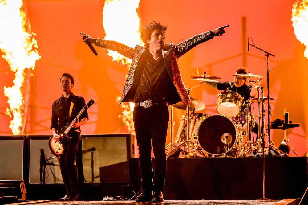 Billie Joe Armstrong em show do Green Day com palco pegando fogo